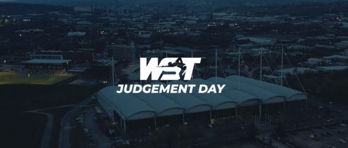 WST Judgement Day in weißen Lettern vor einer abendlichen Ansicht des English Institute Of Sport in Sheffield von oben.