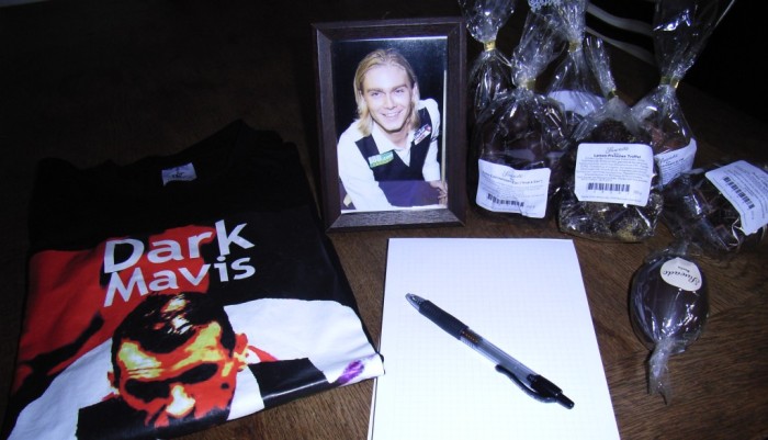 Ausstattung zur Snooker-WM Qualifikation: Ein Tisch mit Notizblock, Foto von Paul Hunter in Spielkleidung, Dark-Mavis-T-Shirt und mehreren Tüten mit Ostereiern.