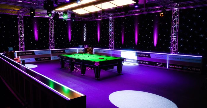 Ein Blick in die noch leere Arena in Milton Keynes vor den Halbfinals der Championship League. Der Tisch und die Umgebung ist violett beleuchtet.