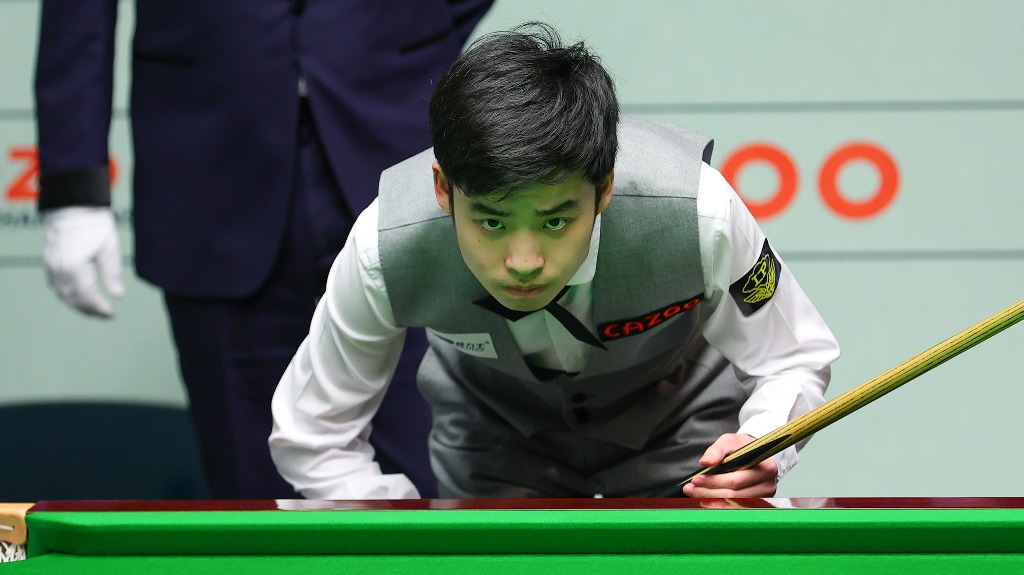 Si Jiahui bei seinem Einzug ins WM-Halbfinale, ein junger Chinesischer Snookerspieler, steht gebückt am Snookertisch und schaut dabei direkt in die Kamera.