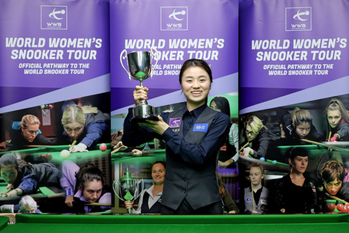 Bai Yulu, eine junge Chinesin, streckt lächelnd den Pokal der British Open in die Luft.