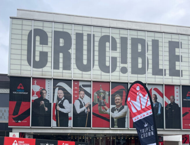 Crucible Theatre mit Spielerbildern an der Fassade, auf einem Wimpel steht 'Triple Crown'