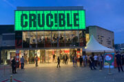 Das Crucible in der Abenddämmerung. Seitlich davor sind ein paar Leute versammelt.