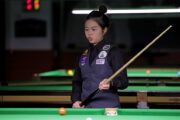 Narucha Phoemphul steht mit dem Queue in der Hand am Snookertisch