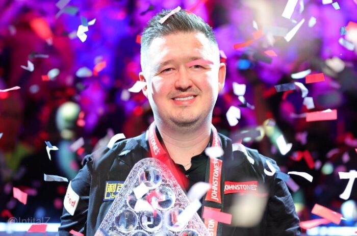 Ein lächelnder Kyren Wilson hält im Konfettiregen die Masters-Trophäe.