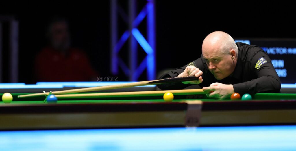 John Higgins (the man) spielt einen Stoß mit dem Hilfsqueue.