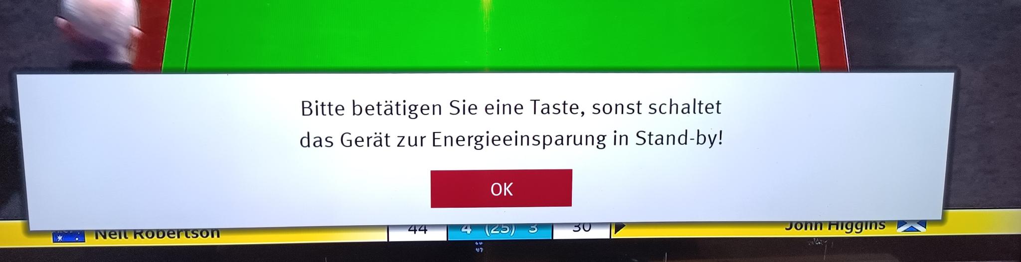 Foto einer Anzeige am Fernseher "Bitte betätigen Sie eine Taste, sonst schaltet das Gerät zur Energieeinsparung in Stand-by!"