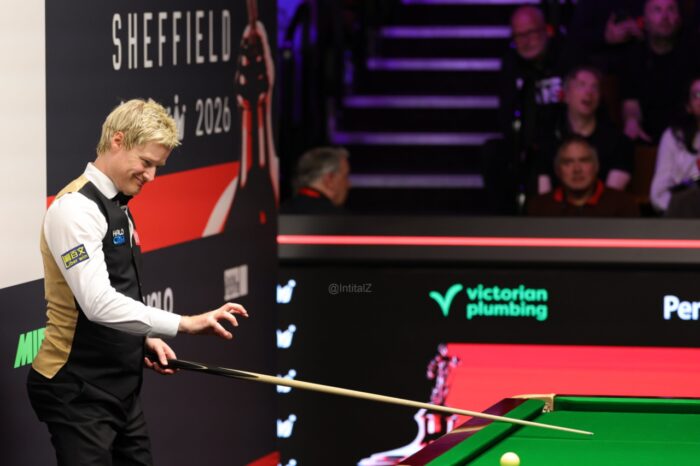 Neil Robertson steht bei der Weltmeisterschaft im Crucible am Tisch. Er grimassiert und hat die rechte Hand zu einer Klaue geformt. Anscheinend versucht er mit übernatürlichen Kräften den Lauf der Bälle zu beeinflussen.
