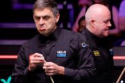 Ronnie O'Sullivan zieht ein Gesicht im Nerven Duell mit John Higgins, der im Hintergrund zu sehen ist.