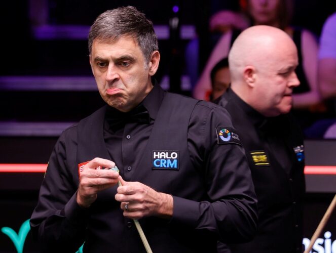 Ronnie O'Sullivan zieht ein Gesicht im Nerven Duell mit John Higgins, der im Hintergrund zu sehen ist.