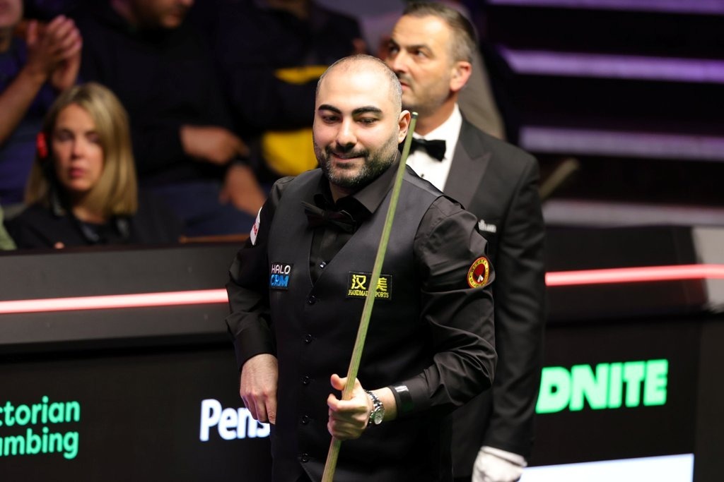 Hossein Vafaei, einen Queue in der Hand haltend und lächelnd