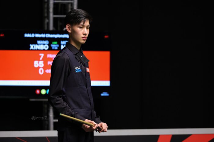 WM-Qualifikation: Wang Xinbo steht mit Queue am Tisch, im Hintergrund das Scoreboard