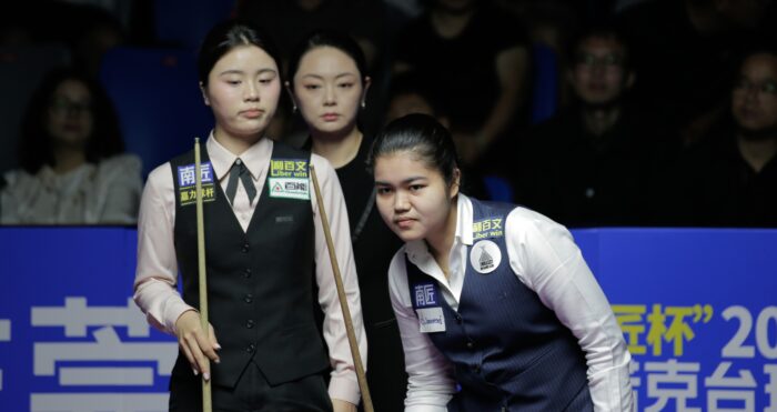 Bai Yulu, Schiedsrichterin Zhou Yanxi und im Vordergrund Panchaya Channoi stehen alle beisammen und werfen einen konzentrierten Blick auf das Spielgeschehen im Viertelfinale der Weltmeisterschaft der Frauen.